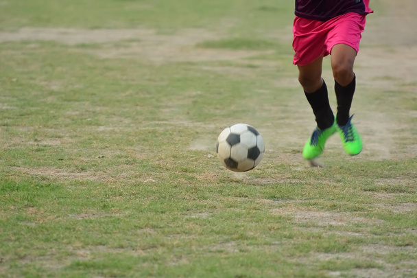 Jogador de futebol está correndo para chutar bola de futebol durante o treino de futebol em campo - Foto, Imagem