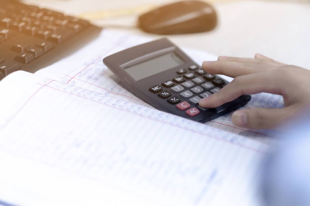 Gli uomini d'affari stanno calcolando un conto entrate e spese utilizzando una calcolatrice
 - Foto, immagini