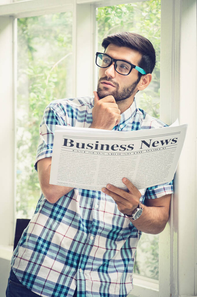 Fiatal alkalmi üzletember olvassa üzleti hírek reggel a - Fotó, kép