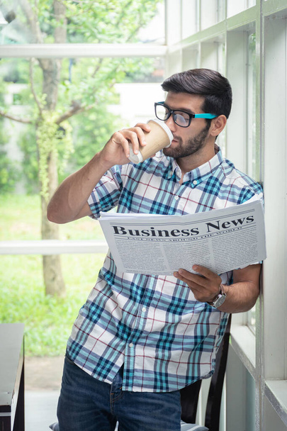 Nuori rento liikemies lukemassa liikeuutisia aamulla osoitteessa
 - Valokuva, kuva