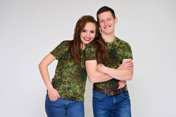 Family Relationship Concept. Portrait of a pleasant young pretty happy family: a brunette girl with a beautiful hairstyle and a guy in uniform on a white background. - Fotoğraf, Görsel