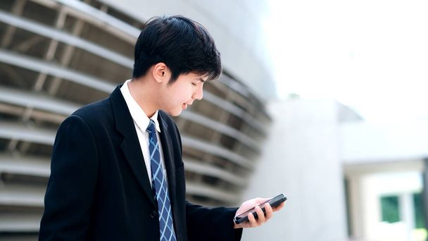 Joven hombre de negocios utilizando mensajes de texto de aplicaciones móviles fuera de offic
 - Foto, imagen