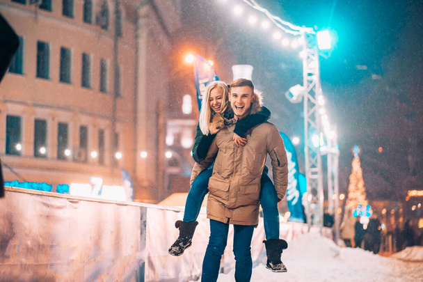 Fröhliches und verspieltes Paar im warmen Winteroutfit tummelt sich - Foto, Bild