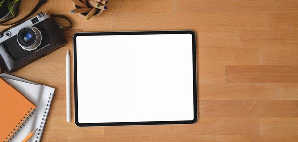 Vista aérea del lugar de trabajo contemporáneo con la tableta digital de pantalla en blanco en la mesa de madera
  - Foto, imagen