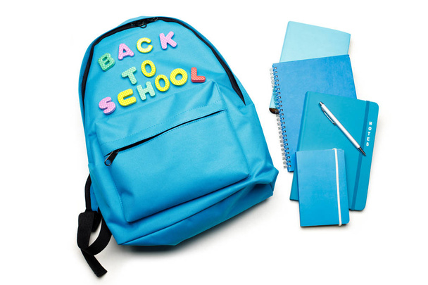 Rucksack mit Schulmaterial, isoliert auf weiß - Foto, Bild