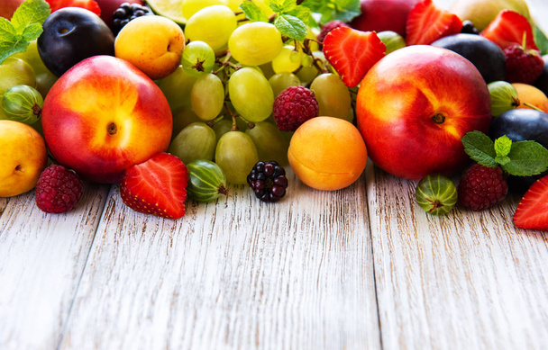 Fresh summer fruits and berries on a white wooden table - Foto, immagini