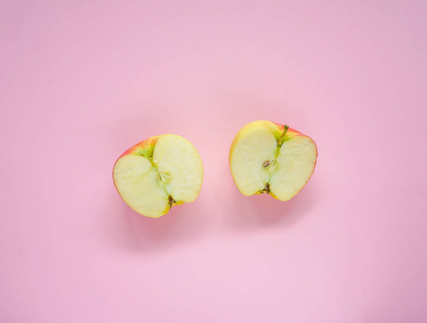 Two apple slices on pink background, flat lay, minimalism, top view, creative concept - Фото, изображение