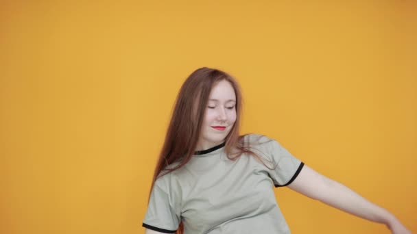 Joyful young woman in casual clothes rising hands with closed eyes - Video