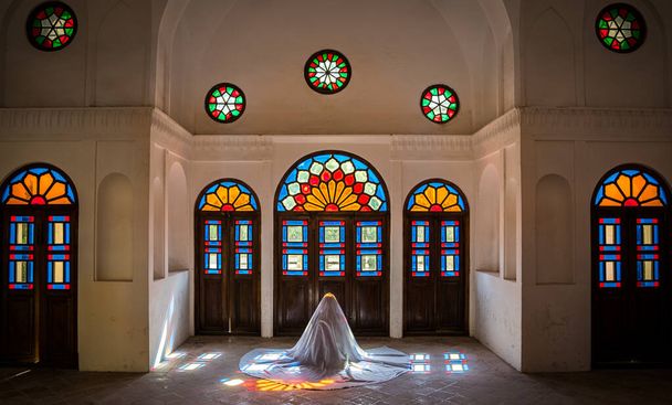 Unidentified Iranian woman in chador hijab praying inside Tabatabaei Natanzi Khaneh Historical House in Kashan, Iran - Photo, Image