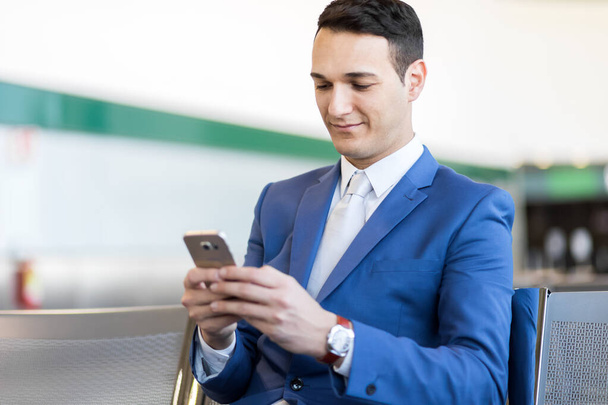 Homme d'affaires utilisant le téléphone à l'aéroport - Photo, image