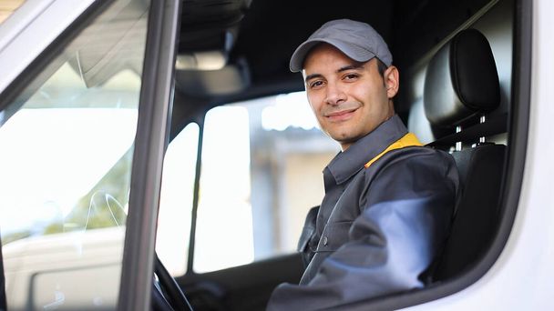 Smiling deliverer man driving a van - Фото, изображение