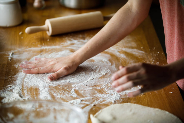 Closeup of woman cooking meal with dough - Foto, afbeelding
