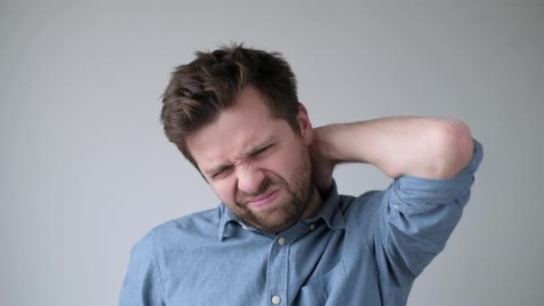 Hombre caucásico guapo que tiene dolor de cuello debido a la osteocondrosis
 - Imágenes, Vídeo