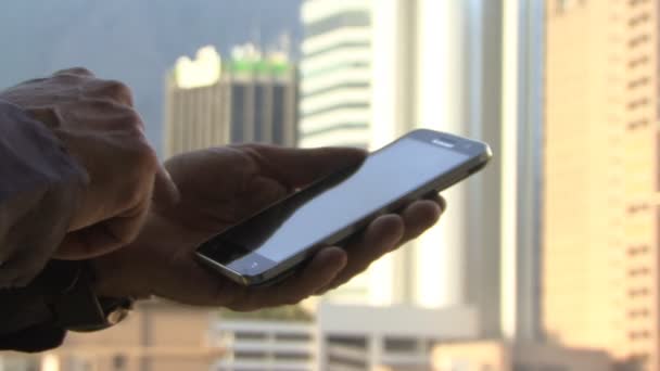 Hombre usando el teléfono inteligente en la ciudad
 - Metraje, vídeo