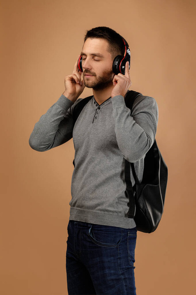 handsome young man with headphones and backpack - Photo, image
