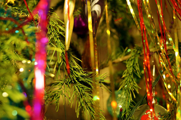 Bright and shiny decorations for Christmas and New Year hang on a green spruce. Winter holidays. - Valokuva, kuva
