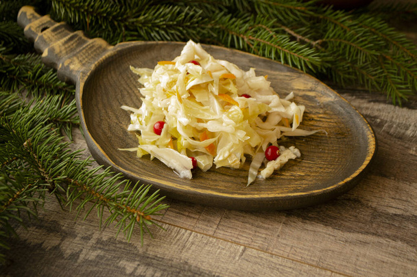 chucrute e cenouras em uma chapa de madeira. Cozinha tradicional russa, comida de inverno
 - Foto, Imagem