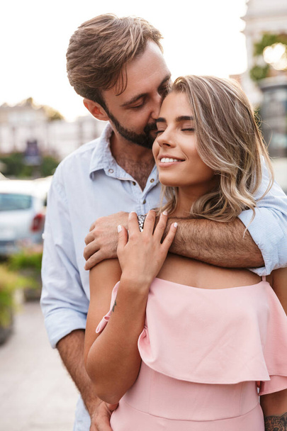 Loving couple walking by street outdoors hugging - Photo, Image