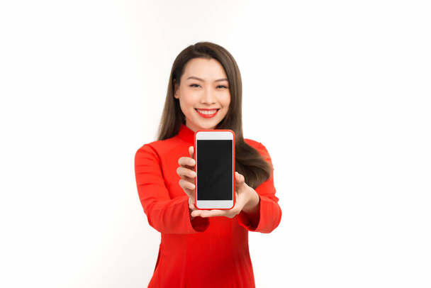 Mulher asiática em vestido vietnamita tradicional, apresentando tela móvel ou aplicativo para negócios digitais e conceito de tecnologia
 - Foto, Imagem