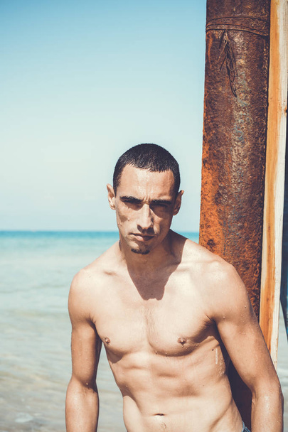 young muscular man resting and posing on the beach - Fotografie, Obrázek