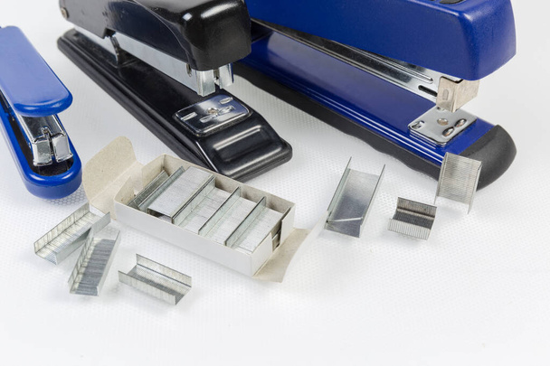 Grampos de metal para os grampeadores de papel contra vários grampeadores
 - Foto, Imagem