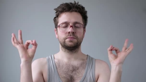 Soustředěný vousatý muž v obrovských brýlích medituje, snaží se uvolnit drží prsty u sebe - Záběry, video