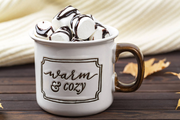 Hot cocoa with marshmallow in a ceramic mug on a wooden table. Concept of home comfort.  - Foto, Imagem