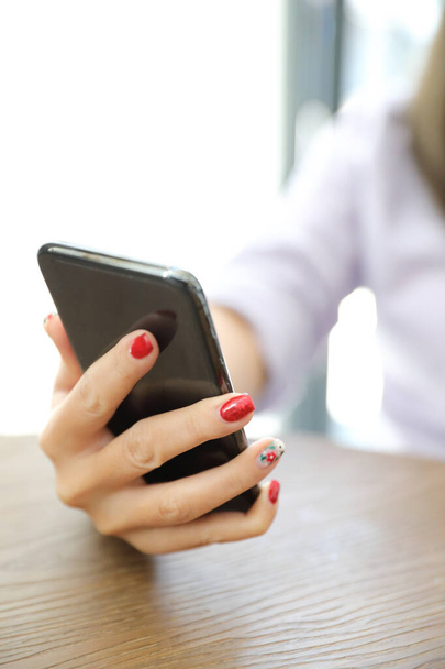 Женская рука с помощью смартфона в бизнесе
 - Фото, изображение