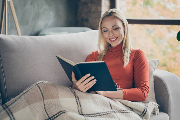 Photo of pretty lady homey mood holding favorite book novel in hands enjoy Saturday morning beloved hobby free time lying comfy couch covered blanket casual outfit flat indoors - Photo, Image