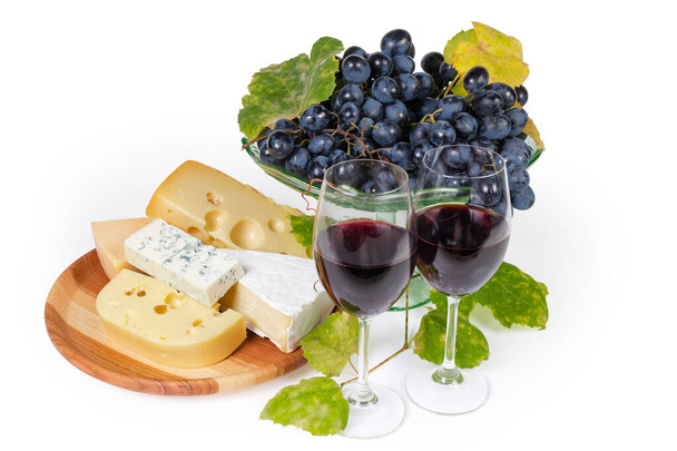 Glasses of red wine against grapes and various cheese - Photo, Image