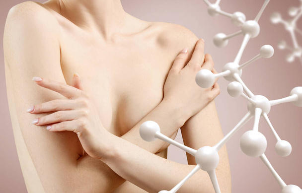 Młoda kobieta sprawdza piersi pod kątem nowotworów w łańcuchu molekuł. - Zdjęcie, obraz