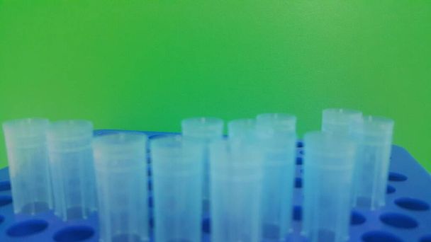 Vue rapprochée des embouts micro-litres bleus dans une boîte à micro-embouts avec trous vides
. - Photo, image
