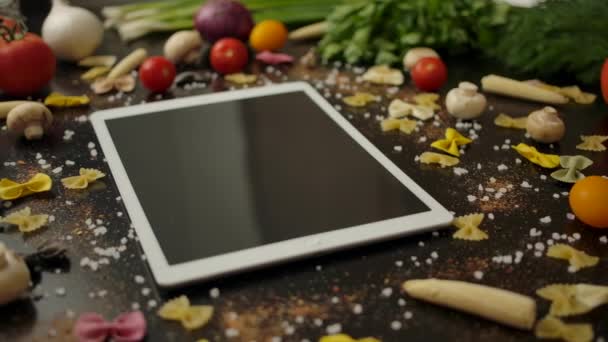 Tablet inmitten von Nudelzutaten in der Küche - Filmmaterial, Video