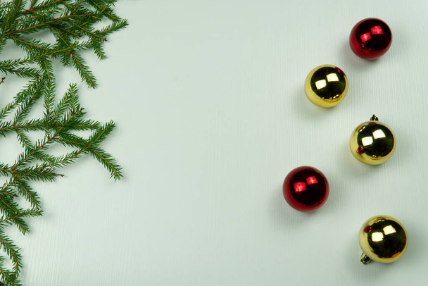 gałązki jodły z szyszki i zabawki świąteczne na białym drewnianym tle. Przestrzeń kopiowania - Zdjęcie, obraz