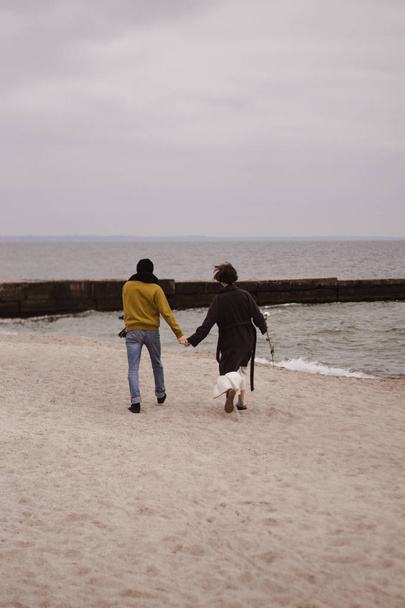 Romantikus pár szórakozik a parton. Boldog pár fut a parton - Fotó, kép