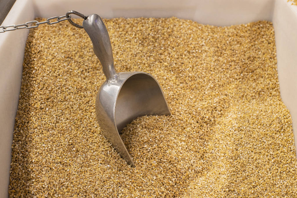 wheat groats background in supermarket counter box with weight spoon  - Photo, Image