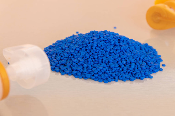 Close-up de grânulos de polímero plástico e garrafa de plástico. Polímero
 - Foto, Imagem