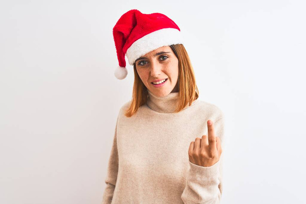 美しい赤毛女性身に着けているクリスマスの帽子上の隔離された背景ベッコーニングはここに来て手でジェスチャー歓迎幸せと笑顔 - 写真・画像