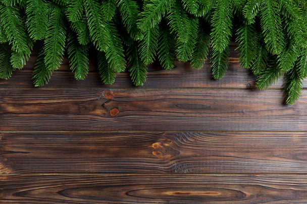 Draufsicht auf Rahmen aus Tannenzweigen auf Holzgrund. Weihnachtskonzept mit Leerraum für Ihre Gestaltung - Foto, Bild