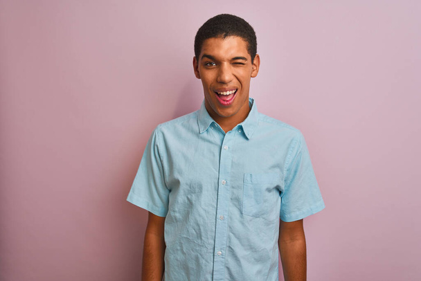 Nuori komea arabi mies yllään sininen paita seisoo yli eristetty vaaleanpunainen tausta silmää katsellen kameraan seksikäs ilme, iloinen ja onnellinen kasvot
. - Valokuva, kuva