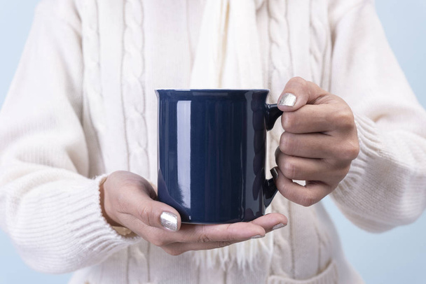 жіноча рука тримає синю керамічну чашку кави. макет для креативної реклами текстового повідомлення або рекламного контенту
. - Фото, зображення