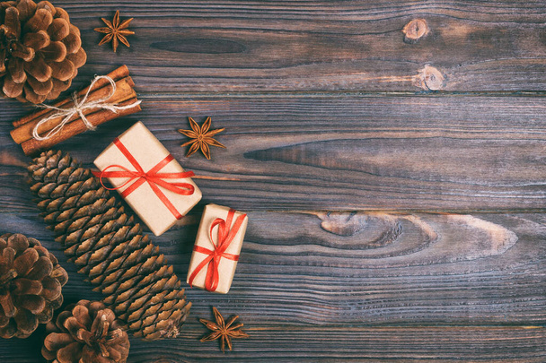 Tahta arka planda bayram dekoru olan bir hediye kutusu. Noel arkaplanı. Üst Manzara. Boşluğu metin için kopyala. Ayarlanmış - Fotoğraf, Görsel