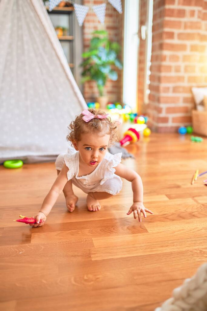 Bela criança caucasiana brincando com brinquedos na sala de jogos colorida. Feliz e brincalhão no jardim de infância
. - Foto, Imagem