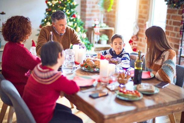 Piękna rodzina uśmiechnięta szczęśliwa i pewna siebie. Jedzenie pieczonego indyka świętującego Boże Narodzenie w domu - Zdjęcie, obraz