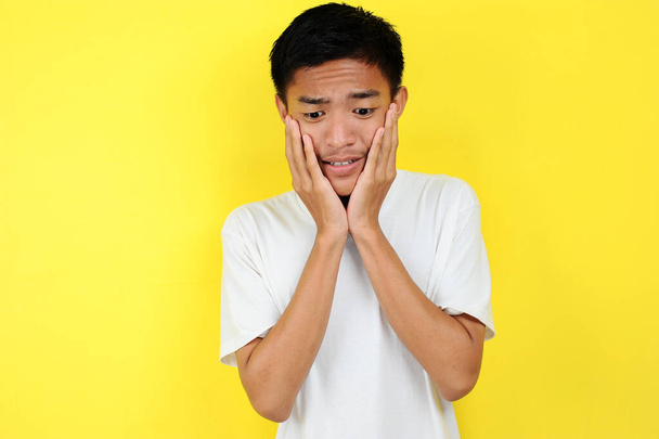 Portret van jonge Aziatische tiener ongelukkige bang man - Foto, afbeelding