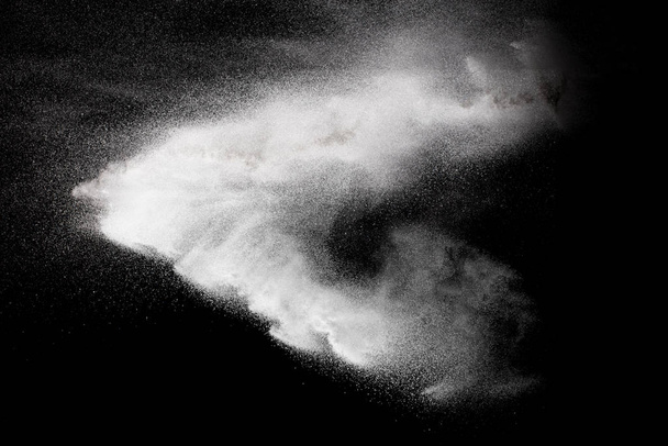 Freeze motion explosie van wit poeder op een zwarte achtergrond.Stoppen van de beweging van wit stof op donkere achtergrond. - Foto, afbeelding
