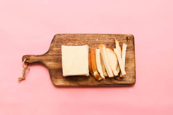 нарізати шматочок хліба в довгу форму на дерев'яній обробній дошці рожевий фон
 - Фото, зображення