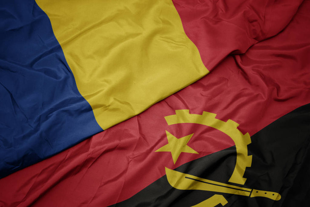 machanie kolorowe flagi angoli i flagi narodowej Rumunii. - Zdjęcie, obraz