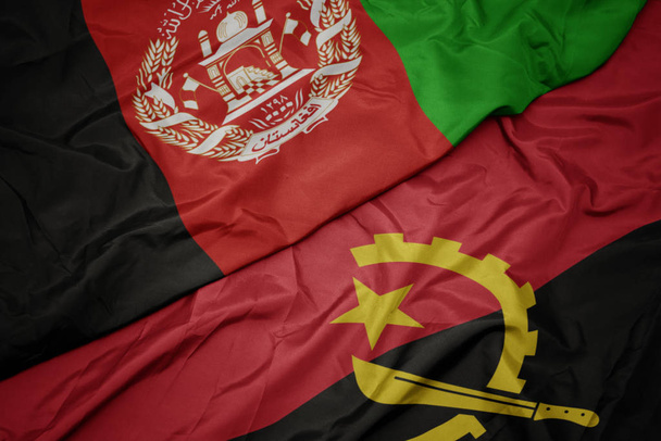 Angola 'nın renkli bayrağı ve Afganistan' ın ulusal bayrağı sallanıyor.. - Fotoğraf, Görsel