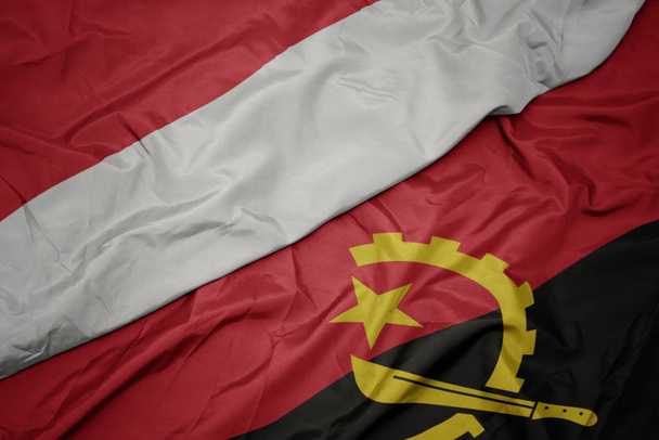 machanie kolorowe flagi angoli i flagi narodowej Indonezji. - Zdjęcie, obraz